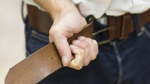 Ein Mann zieht seinen Hosengürtel der Jeans enger